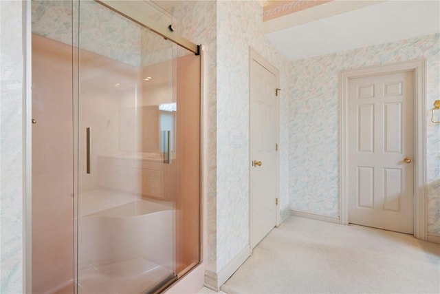 bathroom featuring wallpapered walls and a shower stall