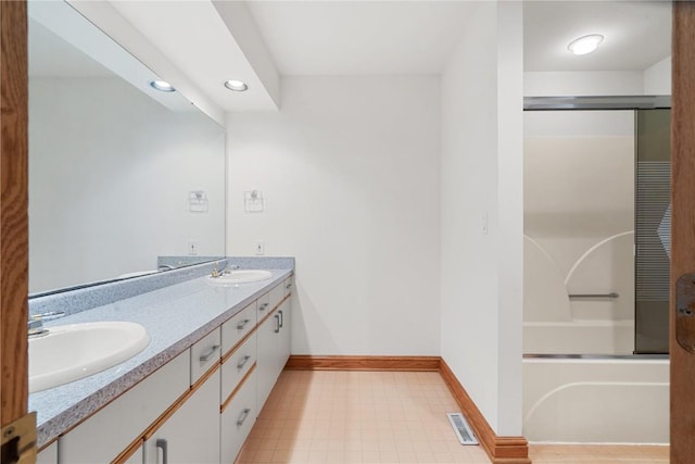 bathroom featuring double vanity, visible vents, baseboards, and a sink