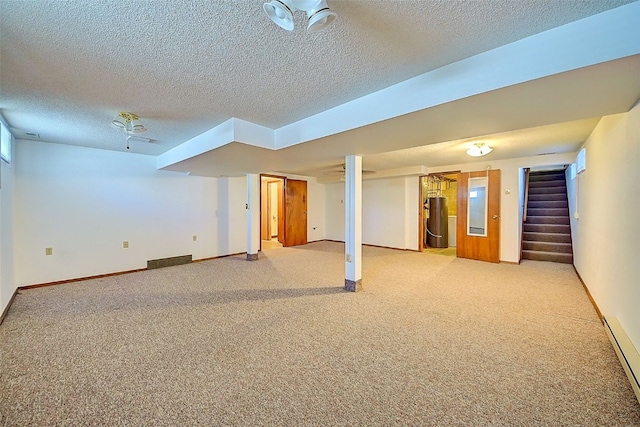 finished below grade area with baseboards, stairway, light colored carpet, water heater, and a textured ceiling