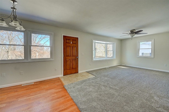 foyer entrance featuring visible vents, baseboards, carpet floors, and ceiling fan