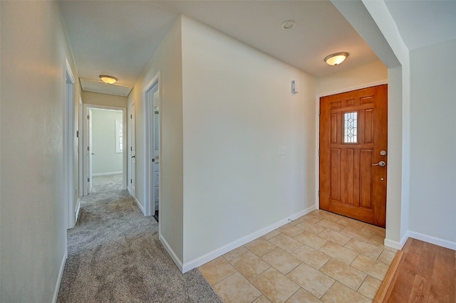 entryway featuring light carpet and baseboards