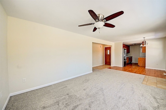 unfurnished room with carpet, baseboards, and ceiling fan