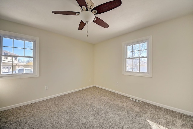 unfurnished room with visible vents, plenty of natural light, baseboards, and carpet flooring