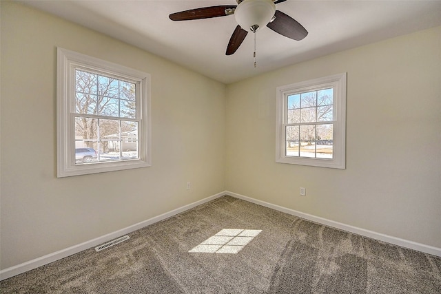 unfurnished room featuring visible vents, carpet flooring, baseboards, and ceiling fan