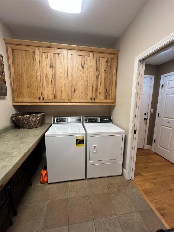 clothes washing area with cabinet space and separate washer and dryer