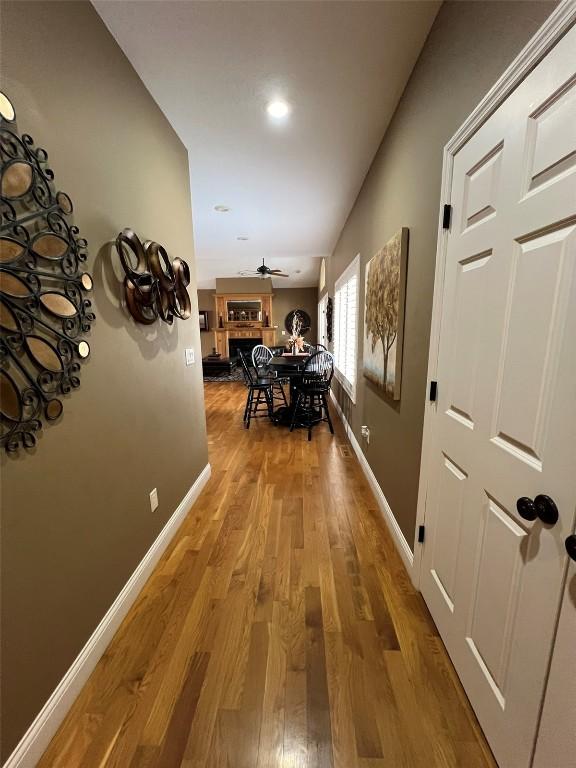 corridor with wood finished floors and baseboards