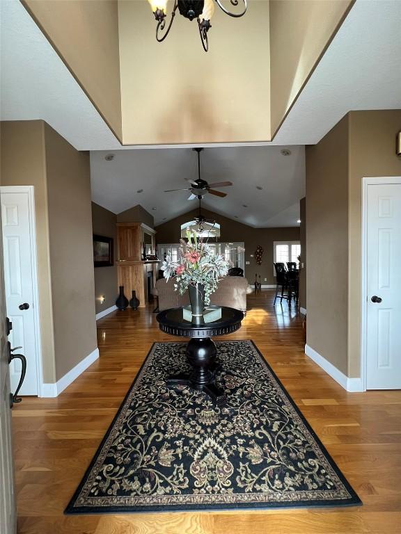 entrance foyer featuring high vaulted ceiling, baseboards, and wood finished floors