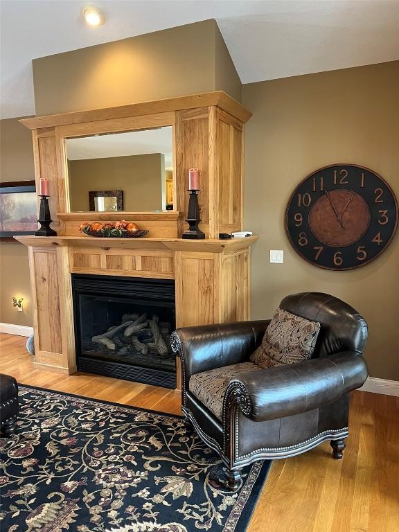 sitting room featuring light wood-style flooring, a fireplace, and baseboards