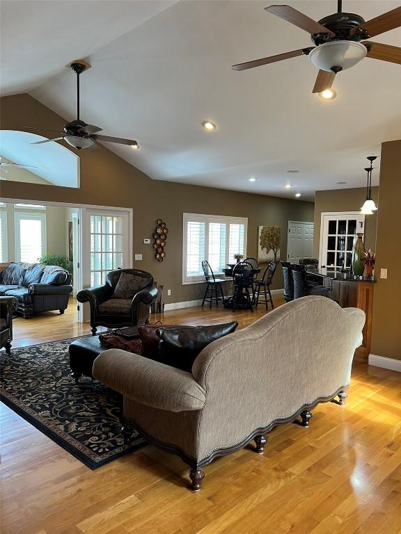 living area with baseboards, recessed lighting, ceiling fan, vaulted ceiling, and light wood-type flooring