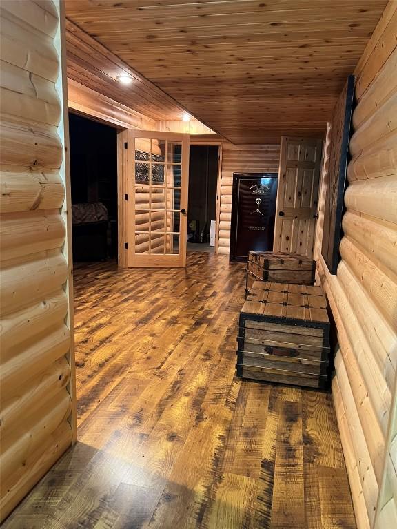 interior space featuring rustic walls, wood finished floors, and wooden ceiling