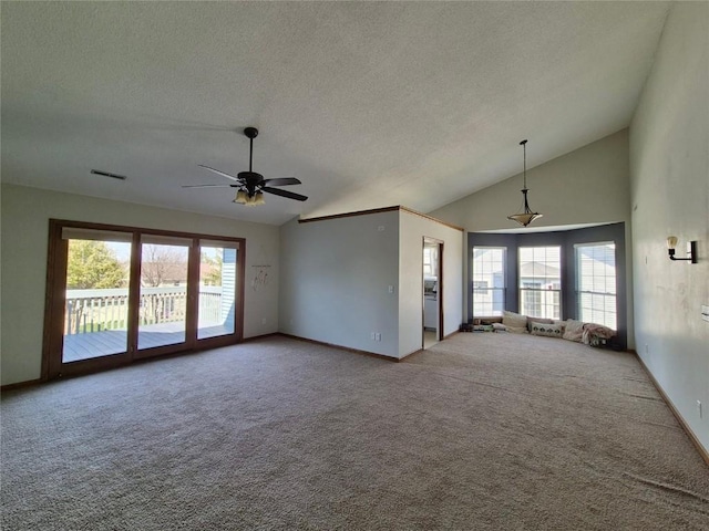 unfurnished living room featuring ceiling fan, lofted ceiling, carpet floors, and visible vents