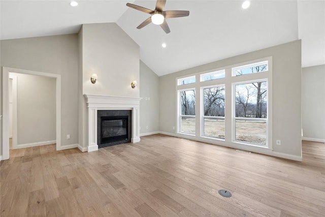 unfurnished living room with baseboards, ceiling fan, light wood-type flooring, a glass covered fireplace, and high vaulted ceiling