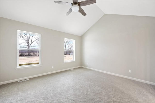 spare room featuring visible vents, carpet flooring, baseboards, ceiling fan, and vaulted ceiling