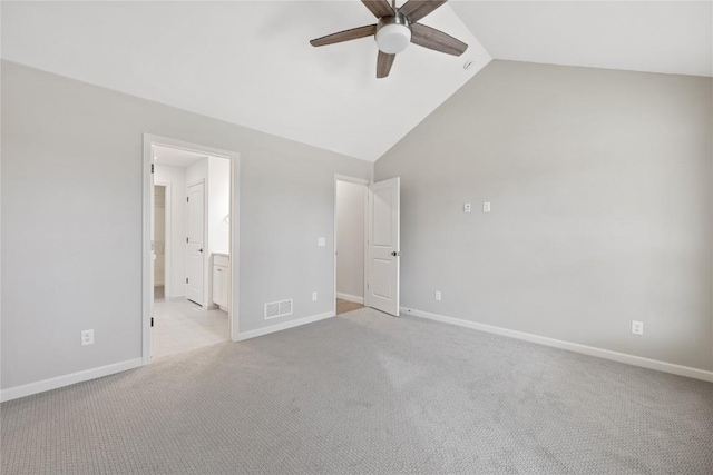 unfurnished bedroom featuring lofted ceiling, baseboards, visible vents, and light carpet