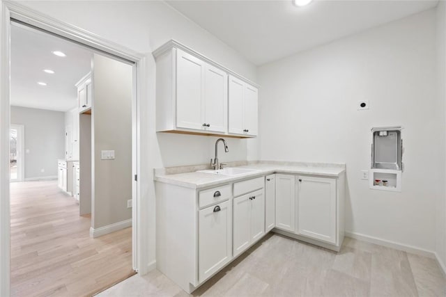 washroom featuring washer hookup, a sink, baseboards, recessed lighting, and cabinet space