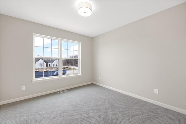 spare room featuring visible vents, carpet flooring, and baseboards