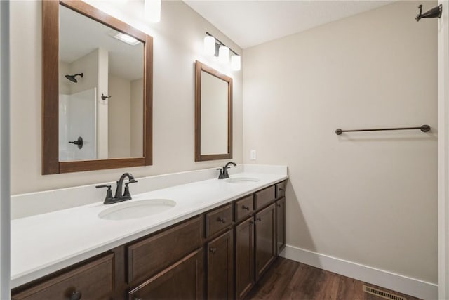 bathroom featuring double vanity, baseboards, visible vents, and a sink