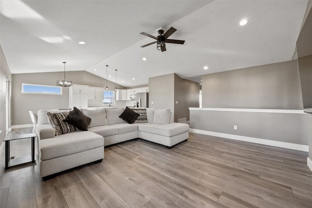 living area featuring lofted ceiling, wood finished floors, and baseboards