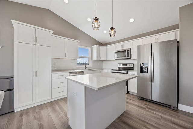 kitchen with appliances with stainless steel finishes, white cabinetry, light wood-type flooring, and a sink