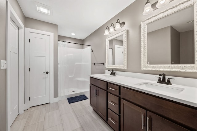 full bath with a sink, visible vents, a shower with curtain, and double vanity