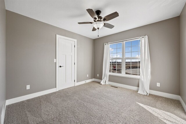 unfurnished room with visible vents, baseboards, ceiling fan, and carpet flooring