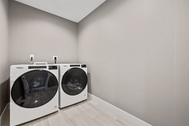 clothes washing area featuring baseboards, independent washer and dryer, and laundry area