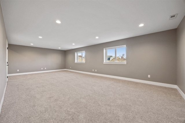 carpeted spare room featuring recessed lighting, visible vents, and baseboards