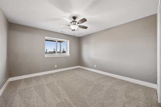 carpeted empty room featuring visible vents, ceiling fan, and baseboards