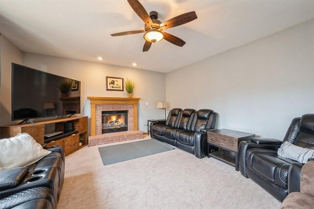 carpeted living room featuring recessed lighting, a brick fireplace, and a ceiling fan