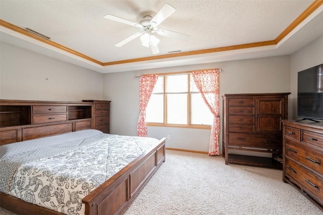 bedroom featuring a ceiling fan, visible vents, a tray ceiling, a textured ceiling, and light colored carpet