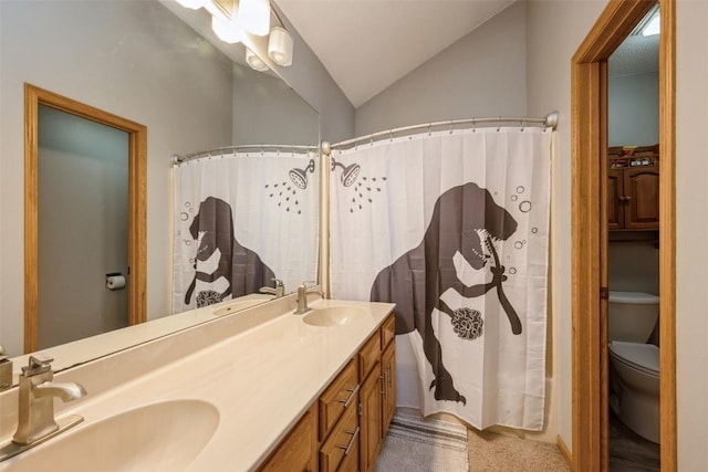 bathroom featuring lofted ceiling, toilet, double vanity, and a sink