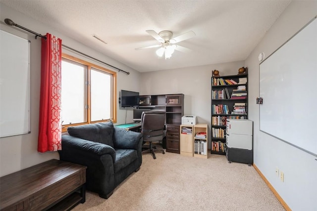 office area featuring baseboards, carpet flooring, a textured ceiling, and ceiling fan