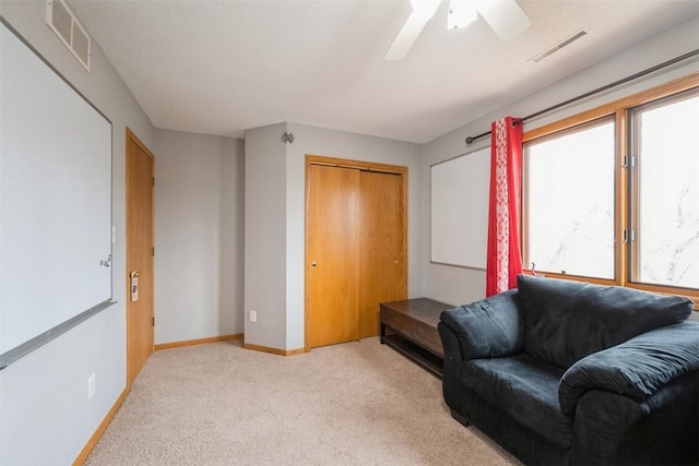 living area with visible vents, carpet flooring, and baseboards