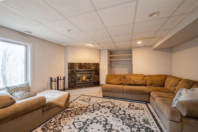 living area with recessed lighting, a premium fireplace, and a paneled ceiling