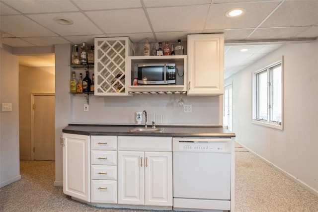 bar with baseboards, wet bar, a sink, dishwasher, and stainless steel microwave