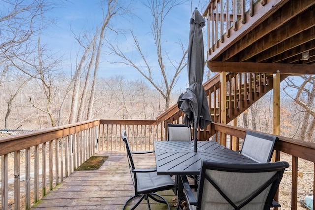 wooden deck featuring stairway and outdoor dining area