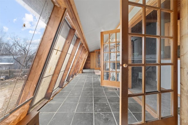 unfurnished sunroom featuring lofted ceiling