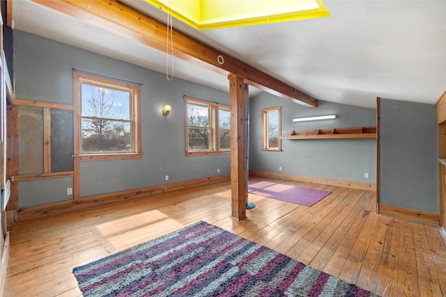 interior space featuring hardwood / wood-style flooring, lofted ceiling with beams, and baseboards