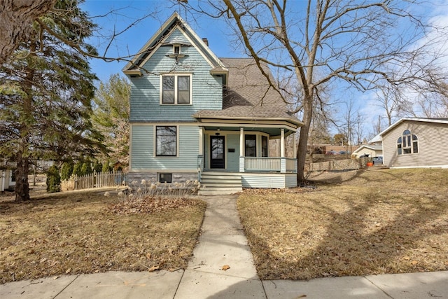 victorian home with roof with shingles, covered porch, and fence