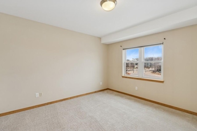 unfurnished room with baseboards and light carpet