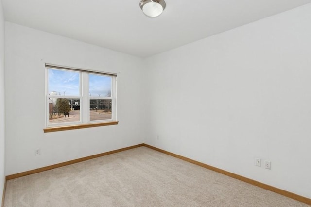 carpeted empty room with baseboards