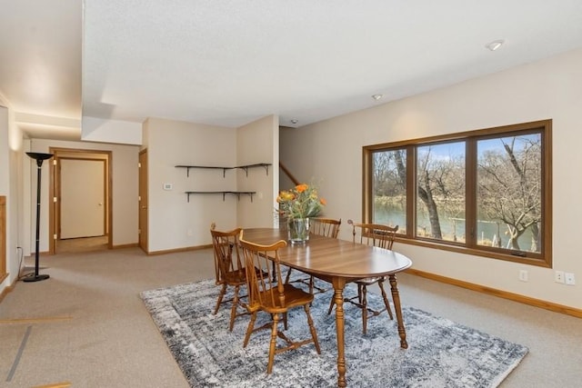 dining area with light colored carpet and baseboards