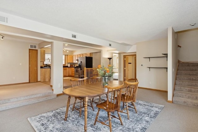 dining area featuring light carpet, visible vents, stairs, and baseboards