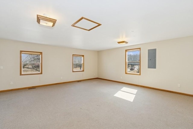 spare room featuring electric panel, baseboards, and carpet floors