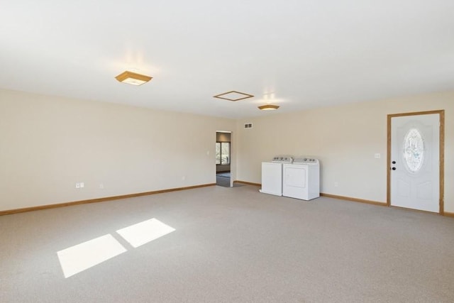 empty room with visible vents, washing machine and dryer, baseboards, and carpet floors