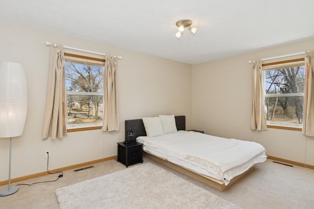 carpeted bedroom featuring visible vents and baseboards