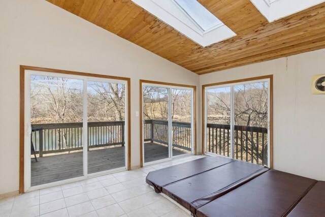 exercise room with lofted ceiling with skylight, light tile patterned flooring, and wooden ceiling