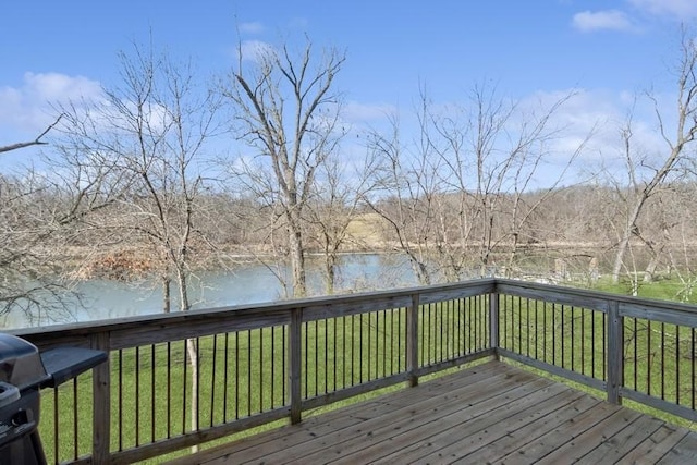 wooden terrace with a yard and a water view