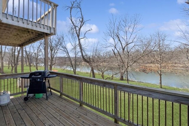 deck with area for grilling, a yard, and a water view