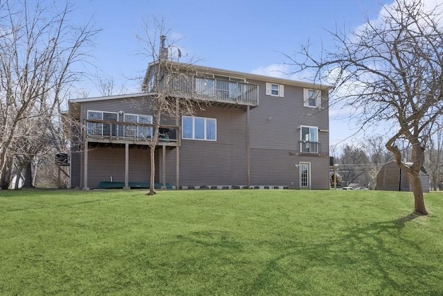 rear view of property featuring a lawn, a balcony, and a chimney